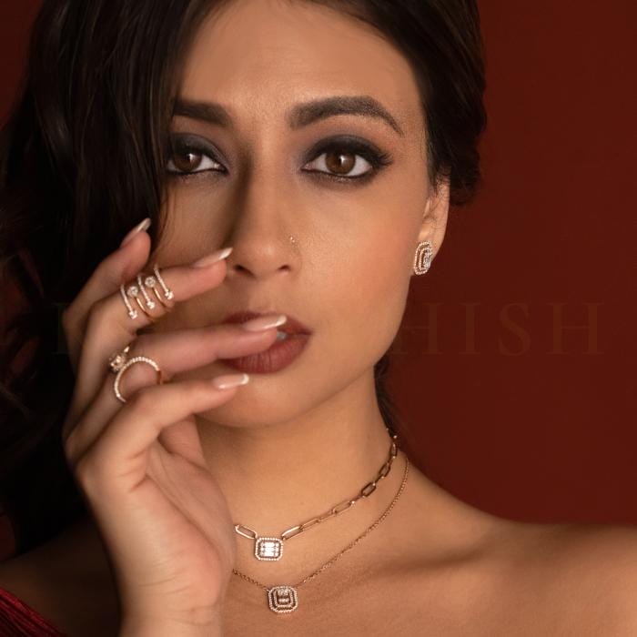 A young woman wearing trendy diamond earrings, necklaces and rings.