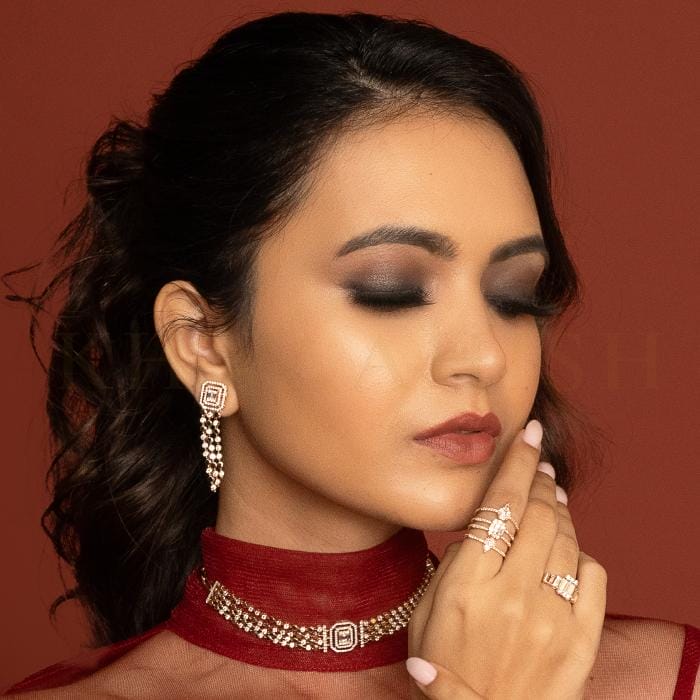 A beautiful young woman poses with trendy and chic diamond rings, a necklace, and matching earrings from Khwaahish.