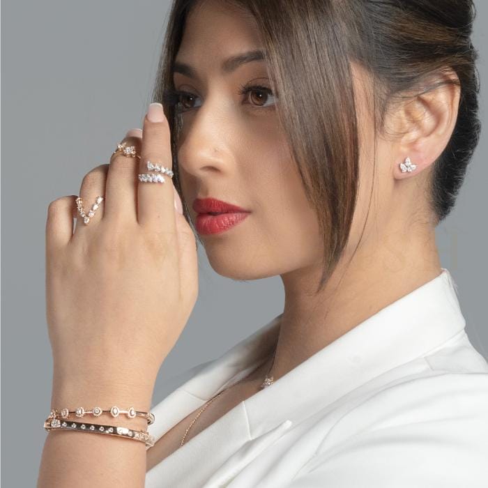 A modern woman poses with trendy and chic diamond bracelets and rings from Khwaahish.