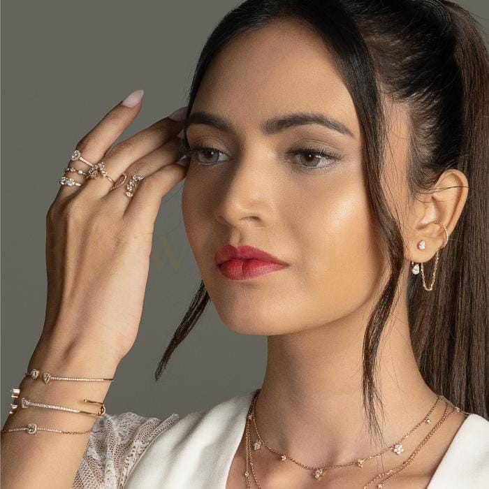 A modern woman poses with trendy rings,necklaces, earrings, and ear charms studded with diamonds from the Gulz collection of Khwaahish.
