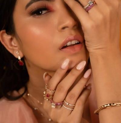 A modern woman poses with trendy rings studded with diamonds and colorful gem stones from the Gulz collection of Khwaahish.
