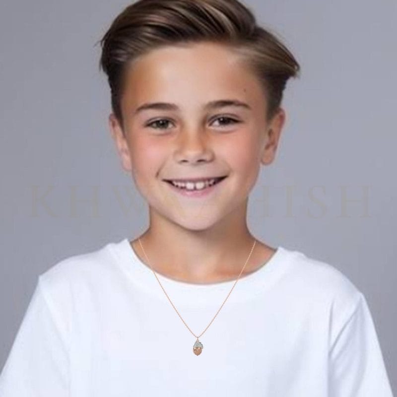 A small boy wearing the Sparkling Santa Diamond Kids Pendant in rose gold.
